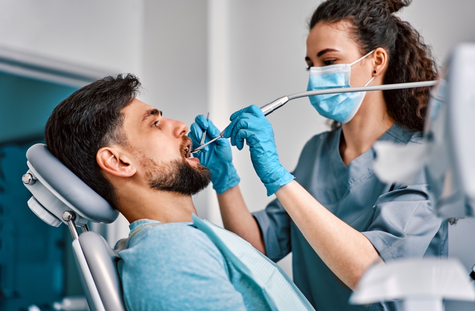 A dental hygienist conducts her patient's dental cleaning.