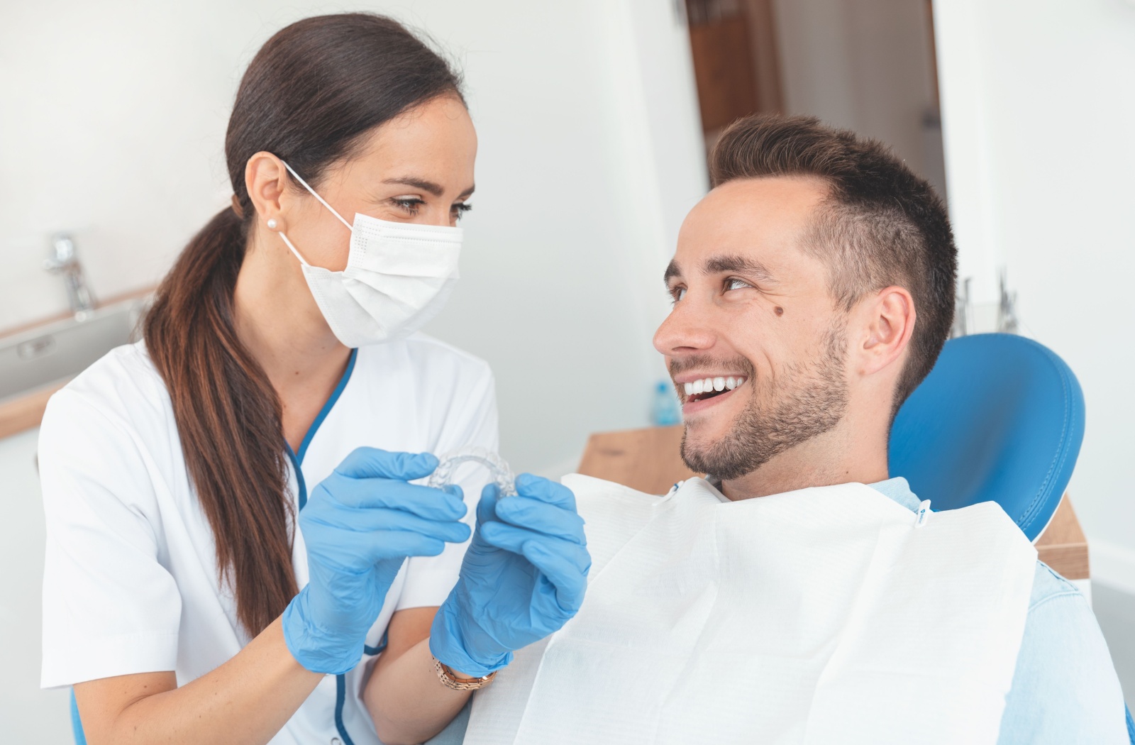 A young man smiling at his dentist during his Suresmile consultation.