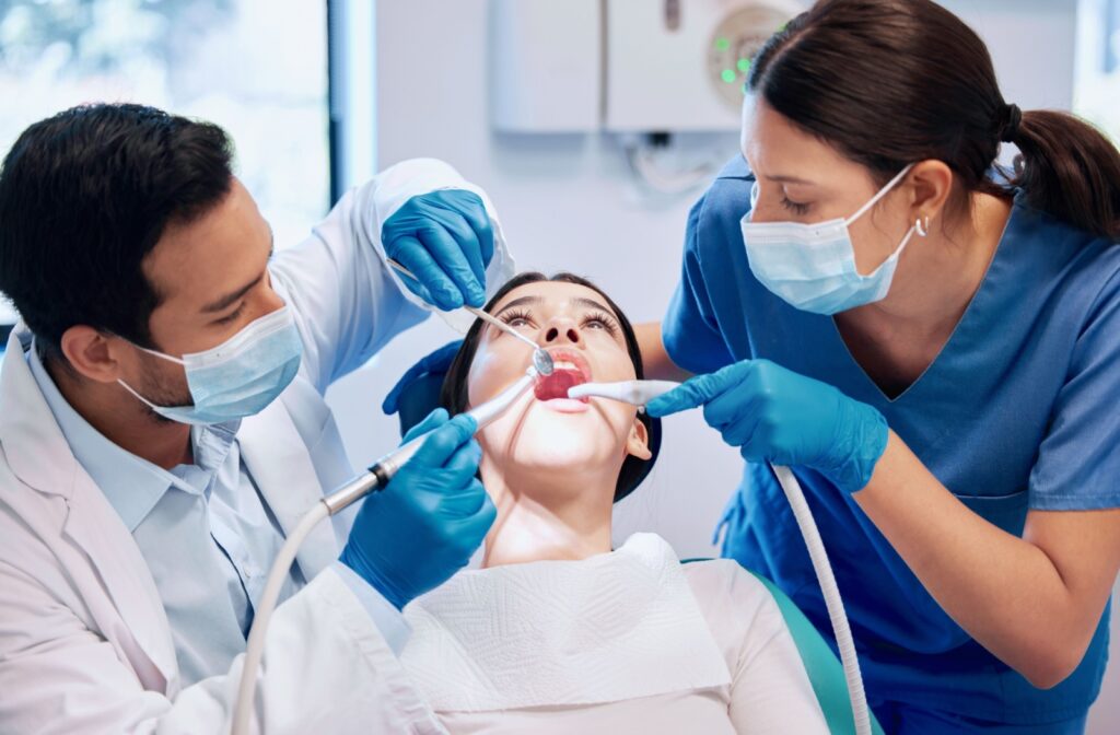 A dentist and assistant performing a professional dental cleaning on a patient ensuring comprehensive oral care in a clinic