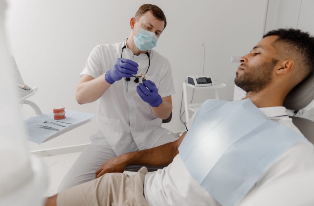 A person sits in a dentist's chair, looking calm and prepared, as they get ready for a root canal procedure in a well-lit dental office.