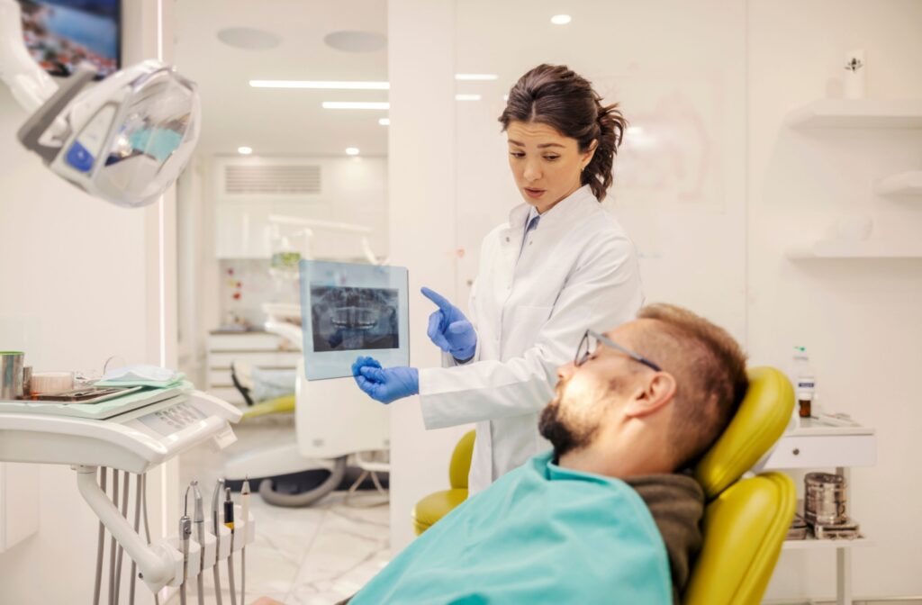 A dentist reviews their patients X-rays with them during a recall exam appointment.