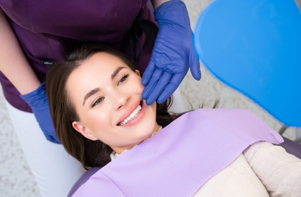 A dentist shows a smiling patient what her new filling looks like.