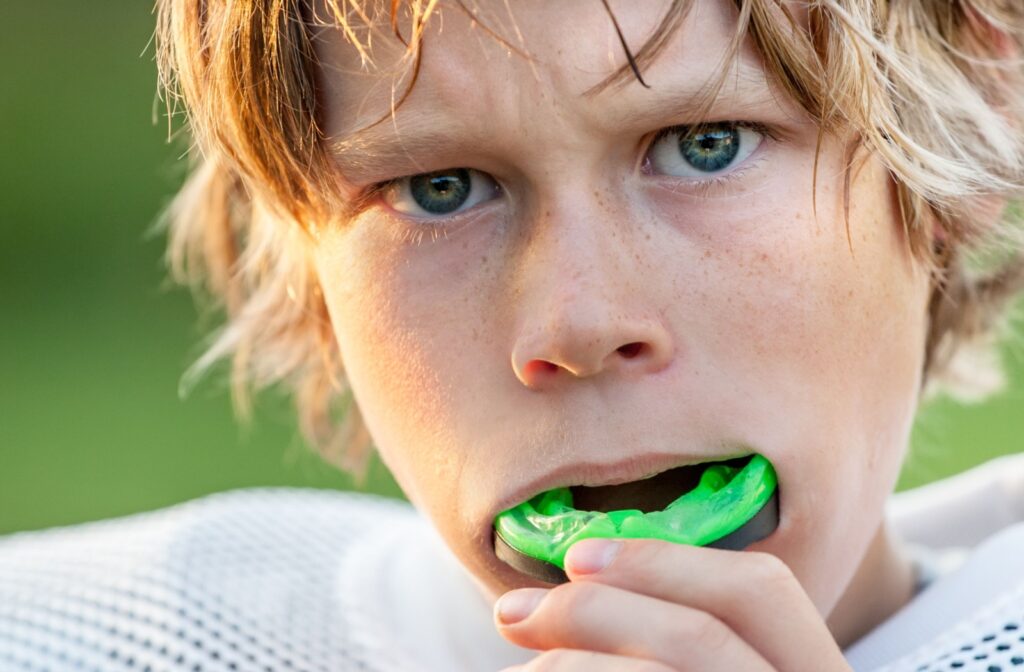 Young athlete wearing a green sports mouth guard during practice.