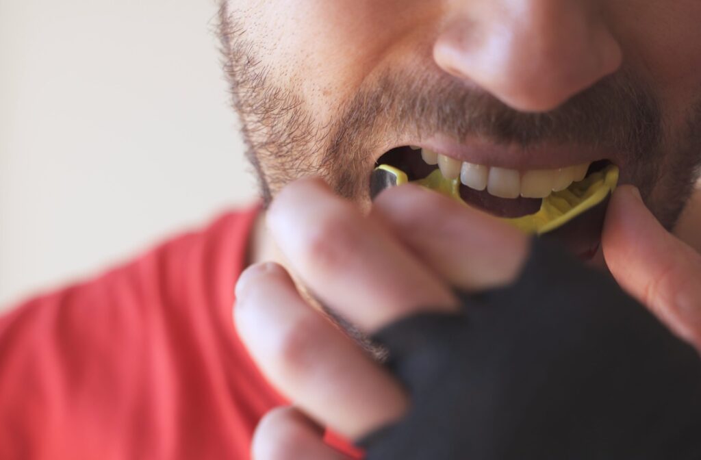 Person putting in a yellow sports mouth guard.