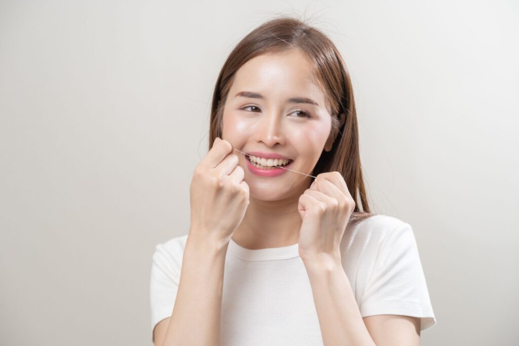 A person flossing in between their front teeth